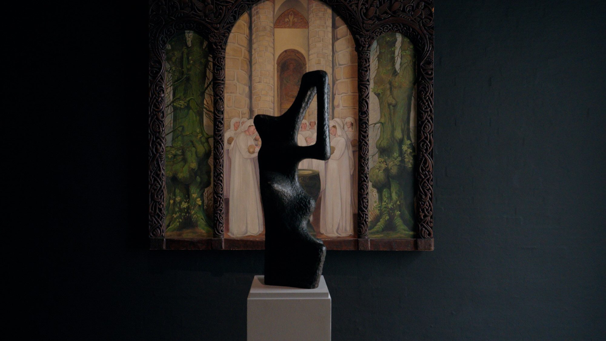 A bronze sculpture in front of Agnes Slott-Møller's triptych