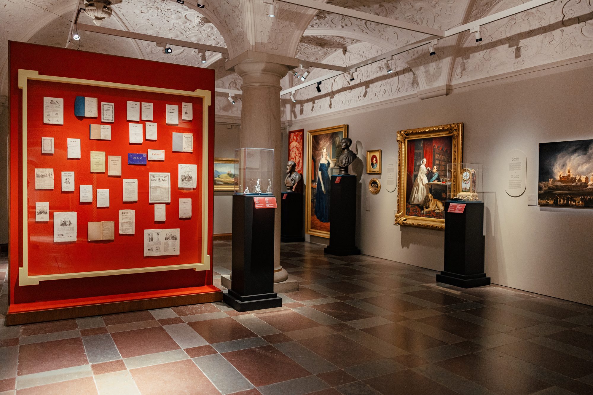 Danner af Danmark, red room with the wall of pamphlets and paintings