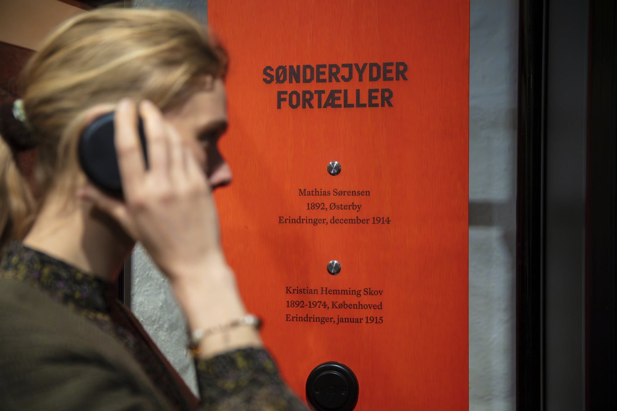 Sønderjyderne og Den Store Krig, a visitor listening to a soldier's memories on the telephone
