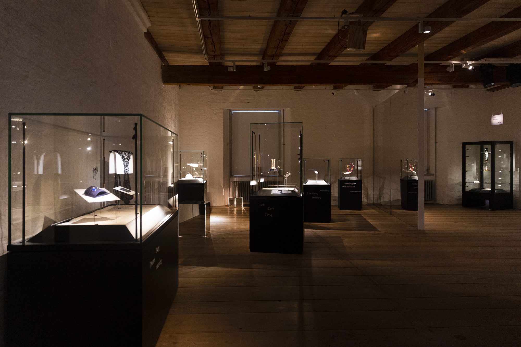Makabre Mesterværker, the dark hall with black vitrines under the castle's timber ceiling