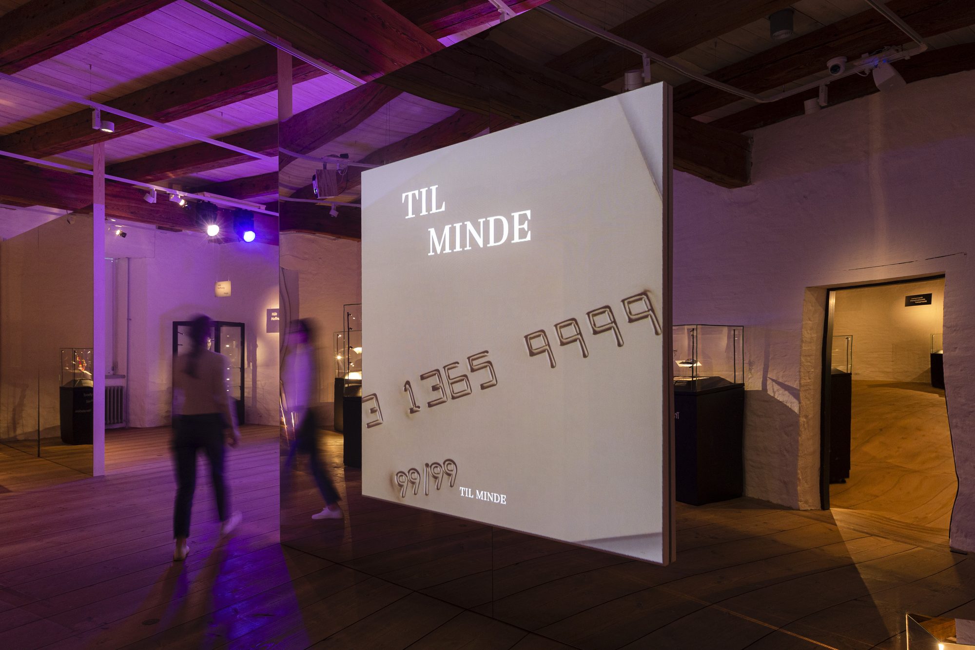 Makabre Mesterværker, the projected title Til minde in the purple-lit hall