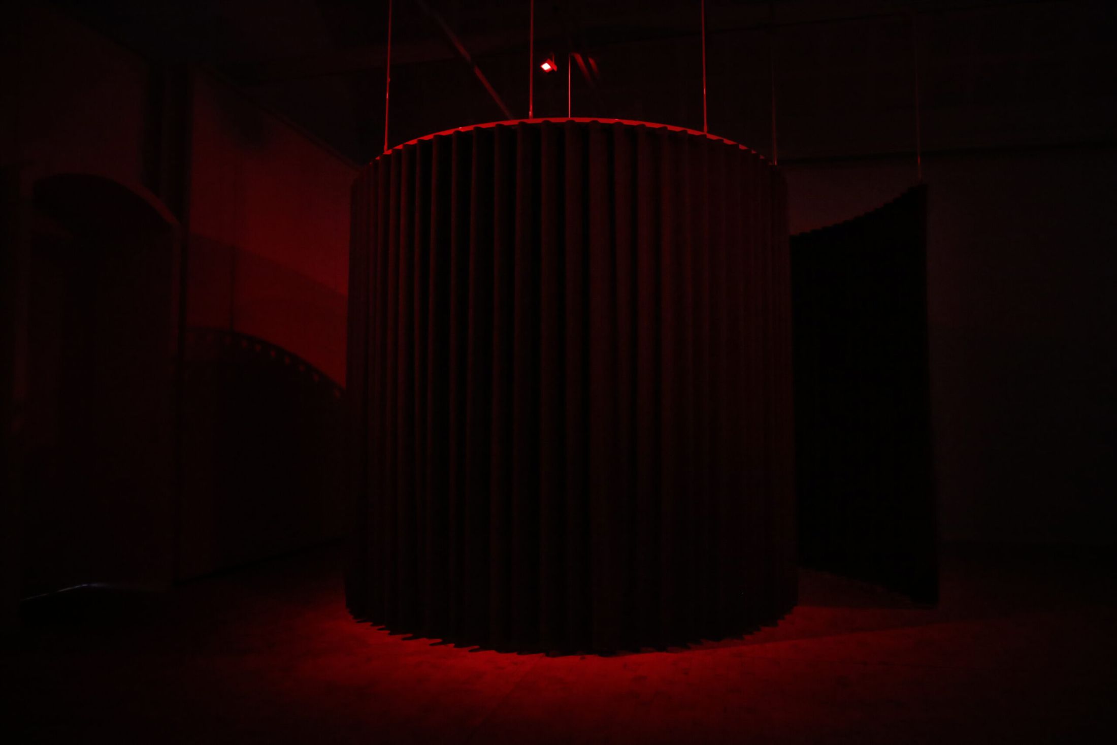 Opus Autopsia, the red curtained cylinder with a single speaker above