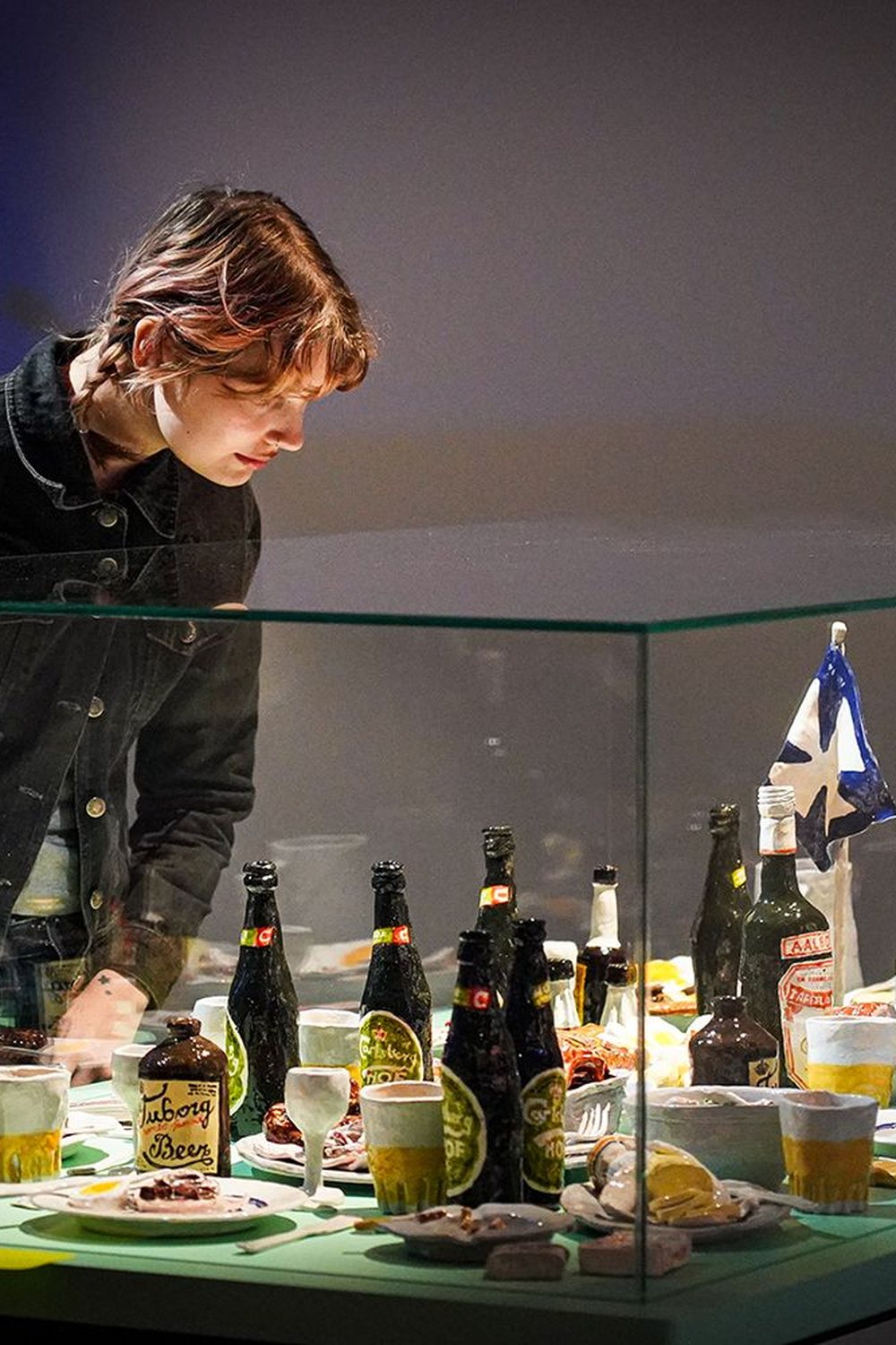 Søfarer, a visitor leaning over the vitrine with the ship's dinner table