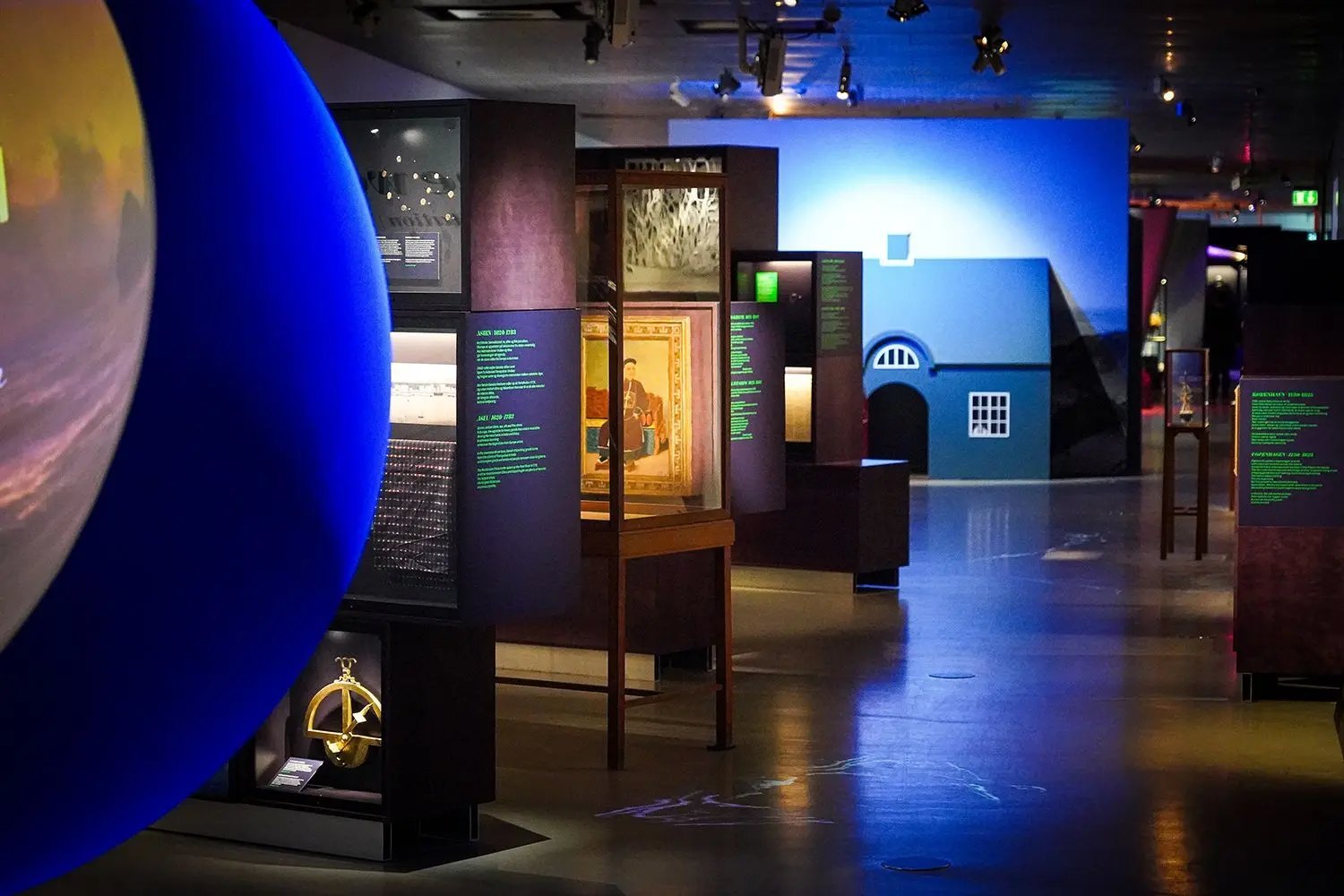 Søfarer, overview of the exhibition with the globe, the vitrines and the blue house