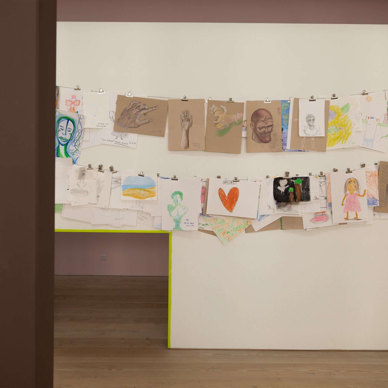 Tegn Amok, the visitors' drawings clipped to a line on the wall