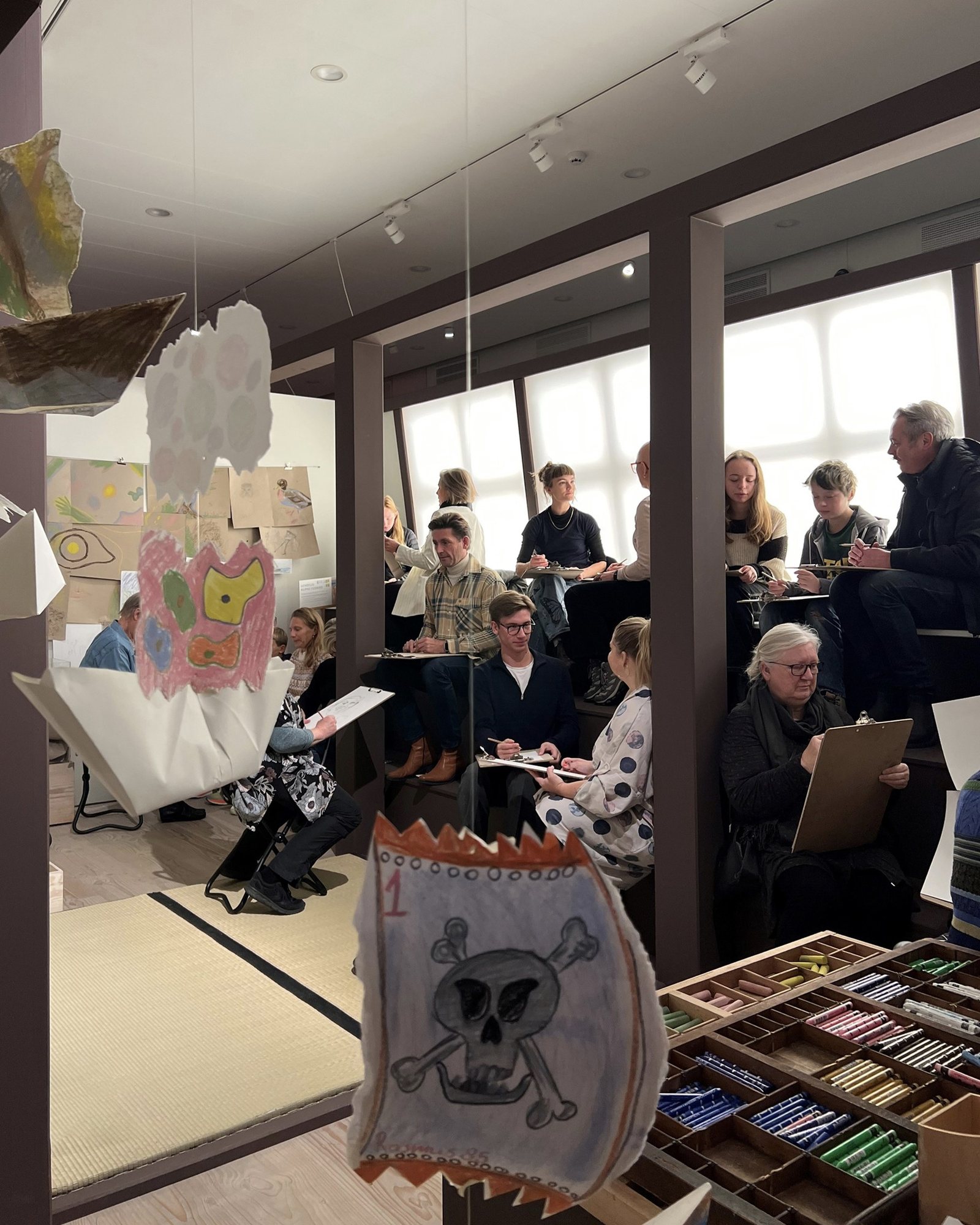 Tegn Amok, the drawing club gathered in the workshop under a paper flag