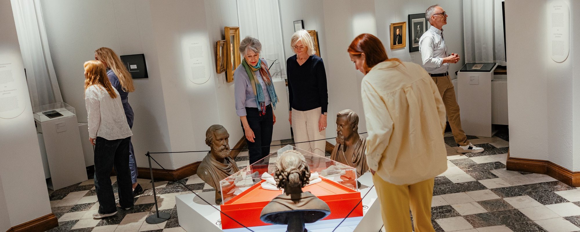 Visitors around the red vitrine in Danner af Danmark